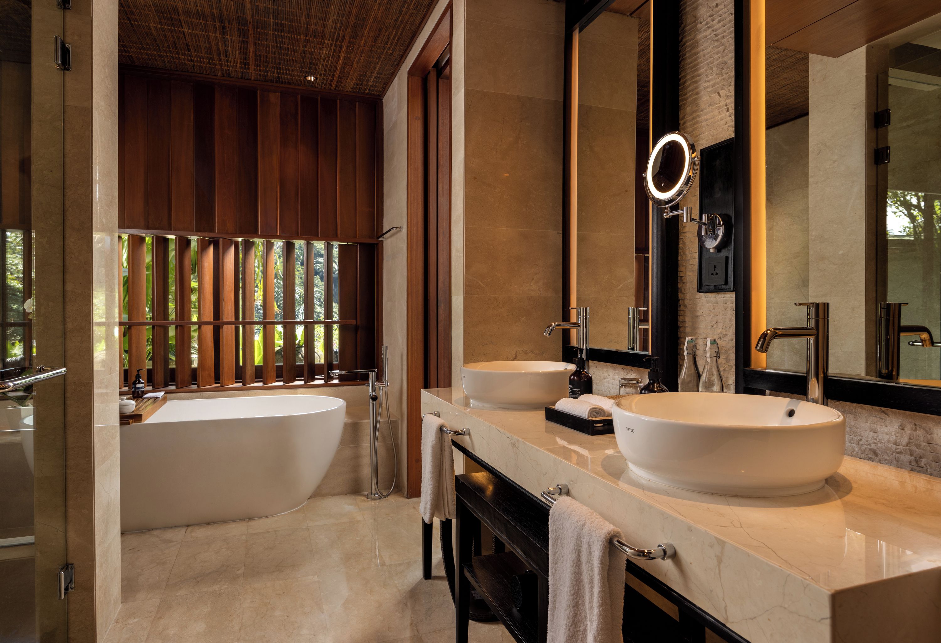 Un baño moderno con una bañera grande, dos lavamanos y un espejo amplio.