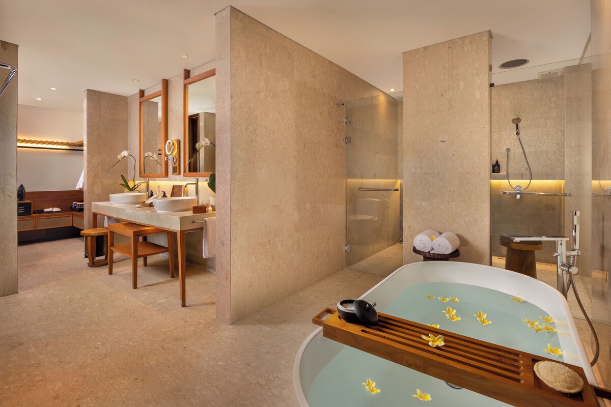 A modern bathroom with a freestanding bathtub, a double sink vanity, a large mirror, and a shower area.