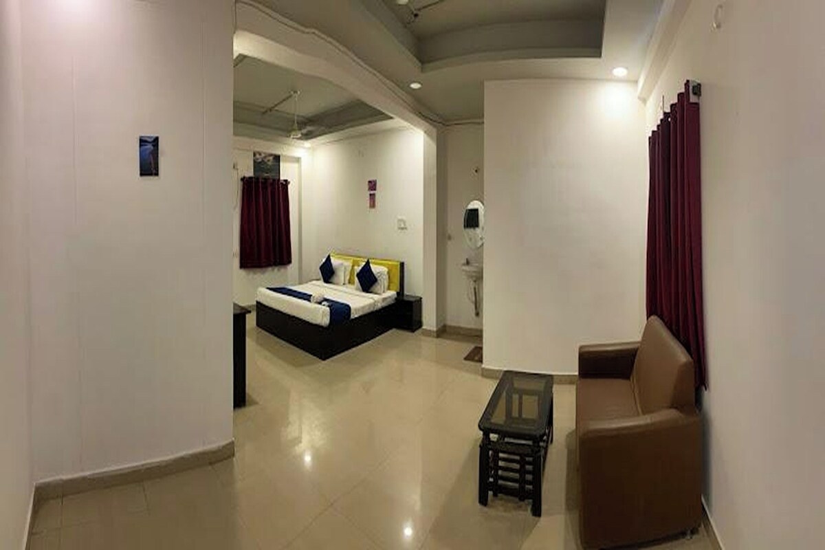 A hotel room with a bed, a seating area, and a small table.