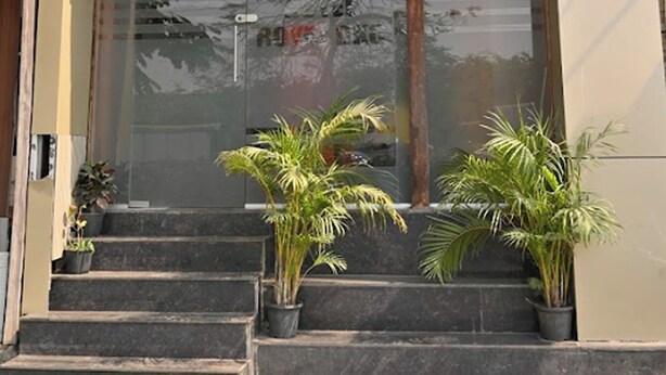 The exterior of Hotel Royal BKC with a prominent sign, a glass entrance, and steps leading up to the door.