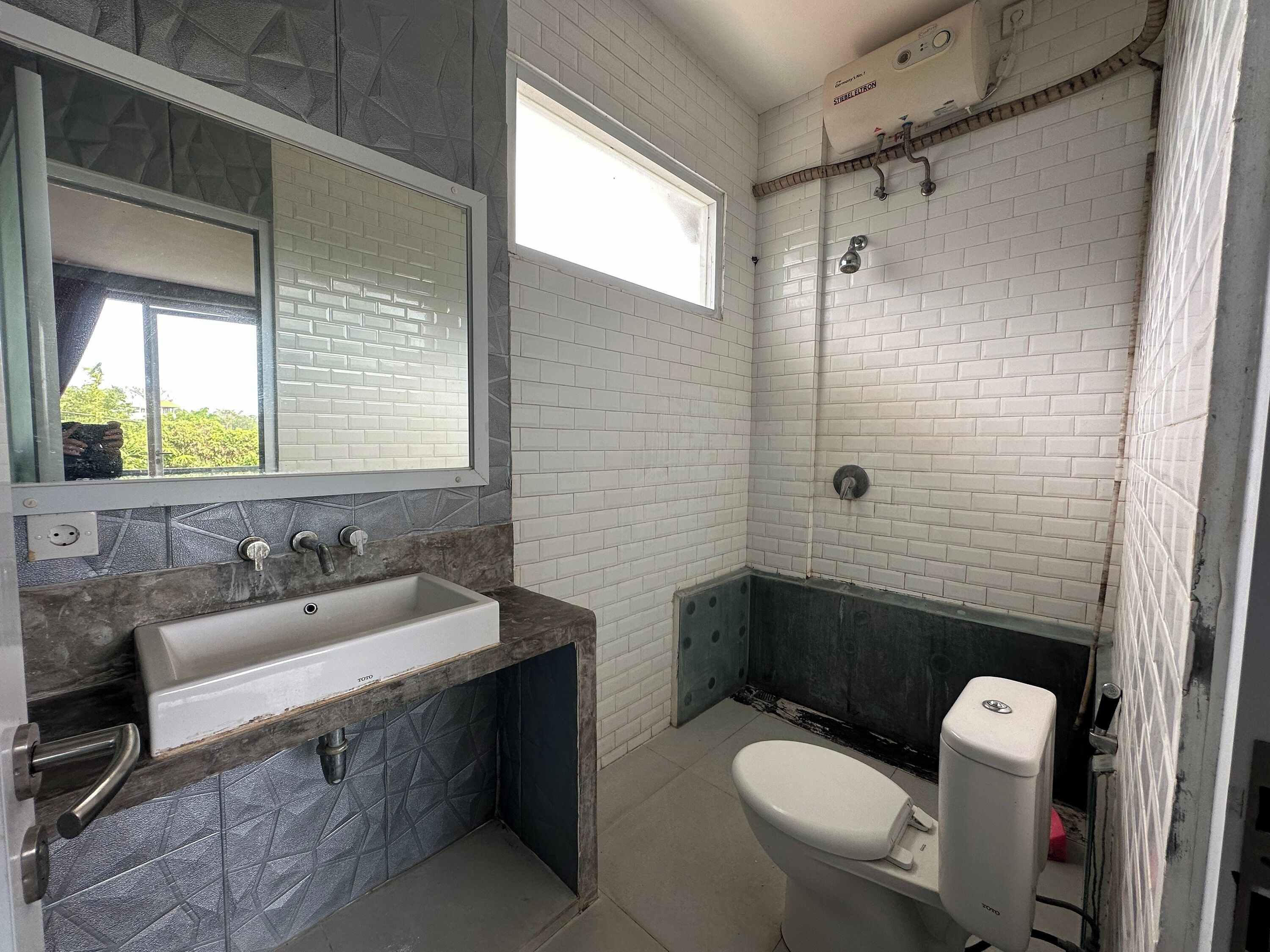 A bathroom with a white sink, a toilet, and a shower area.
