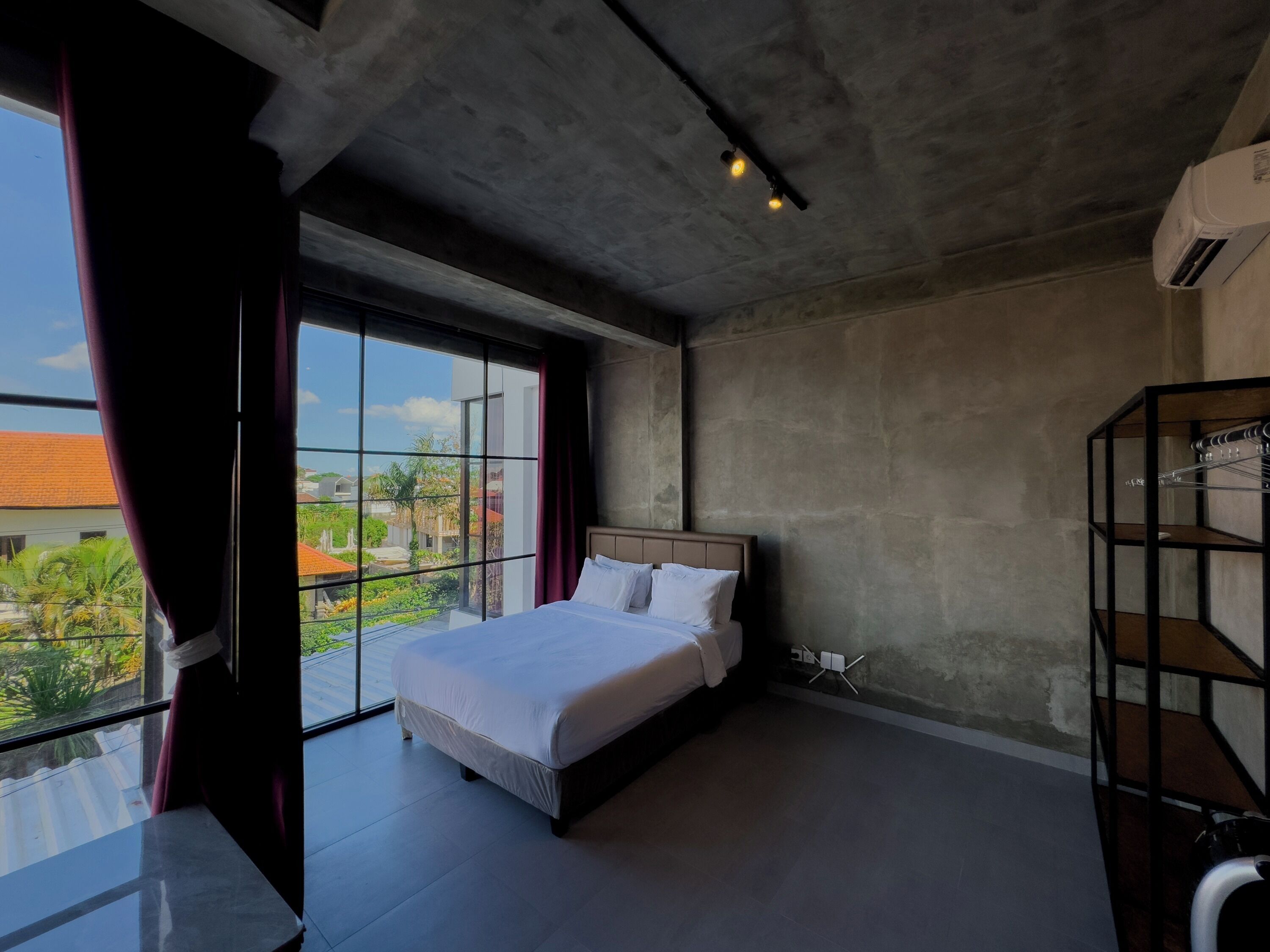 Un dormitorio moderno con una cama grande, un armario y vistas al exterior.