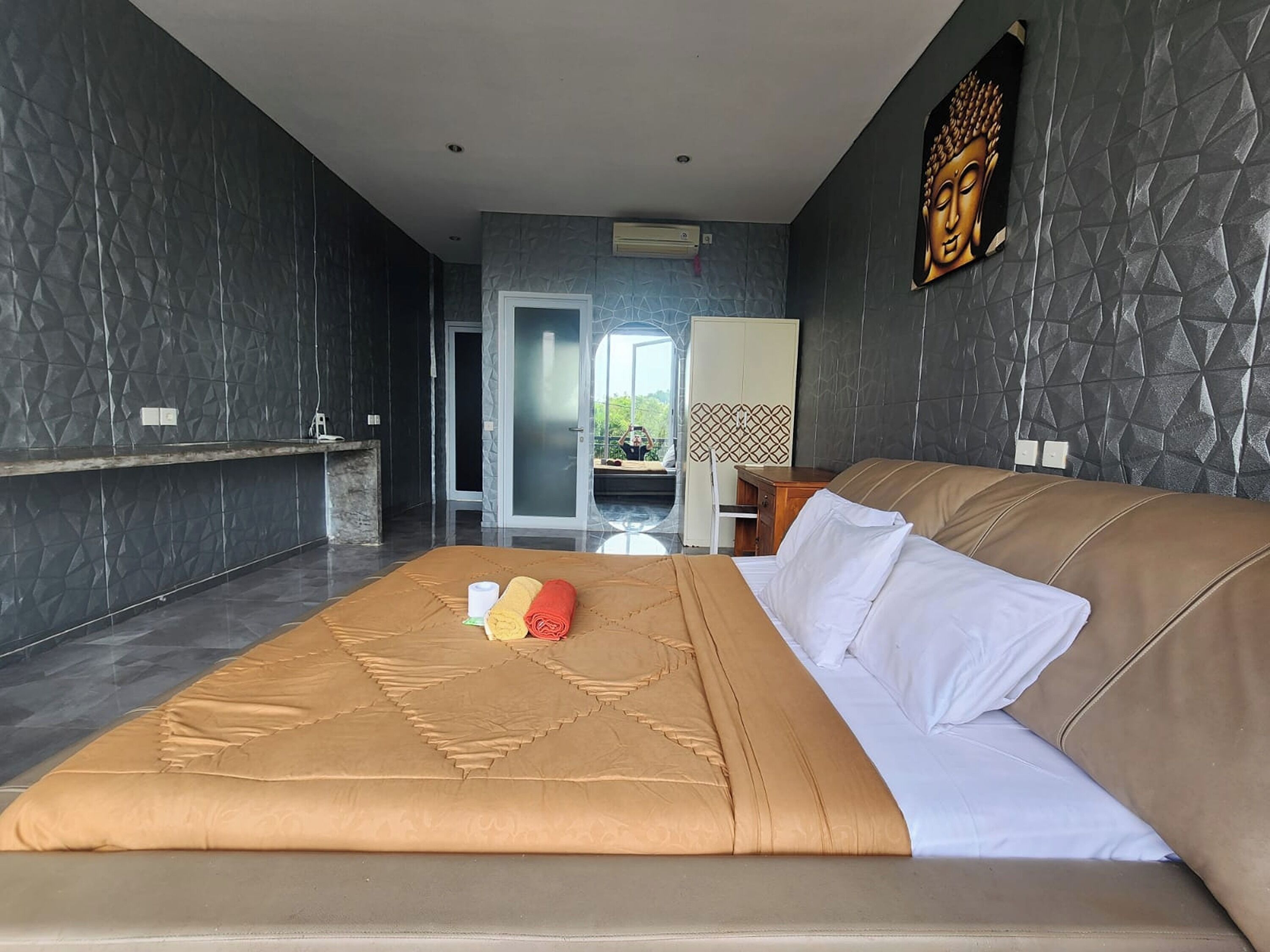 Habitación de hotel moderna con una cama grande, un escritorio y vistas al exterior.