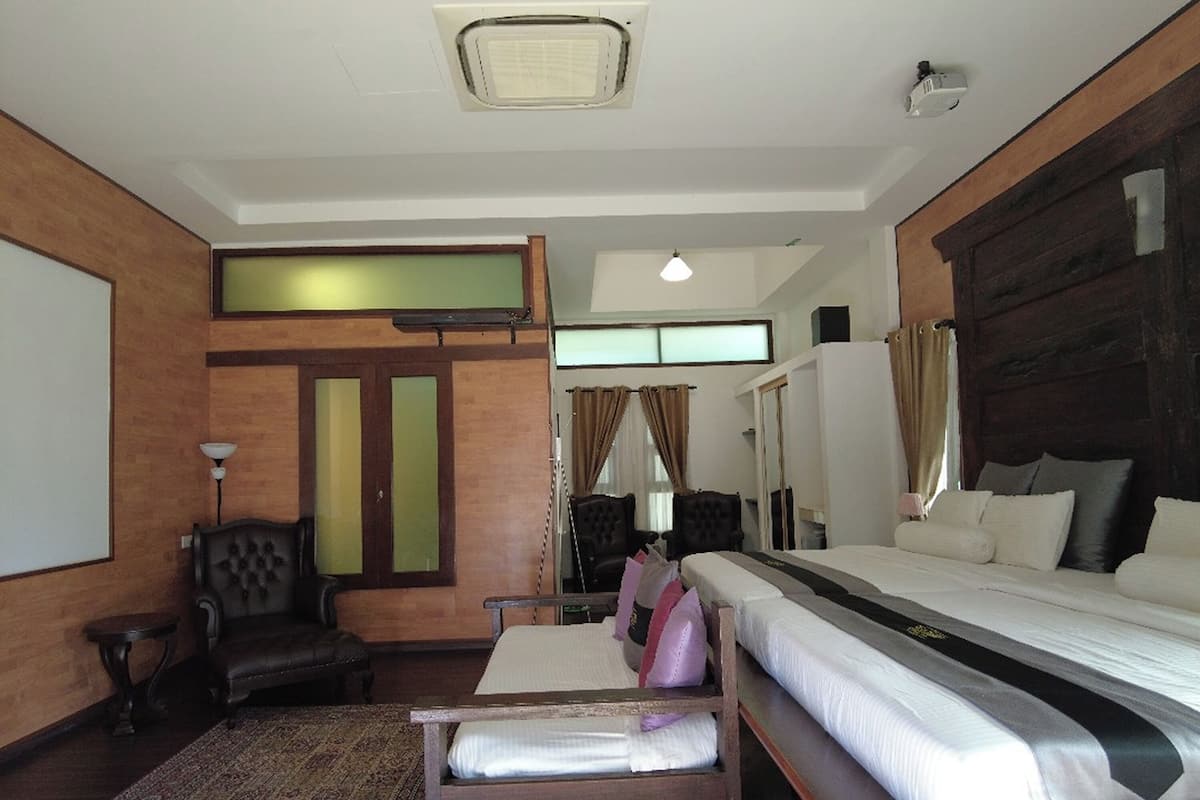 Habitació d'hotel amb un llit gran, un armari de fusta, una taula petita i una cadira.