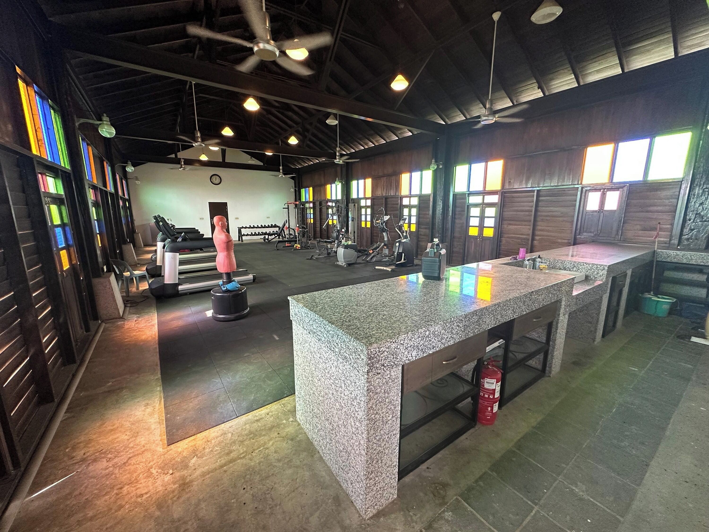 A gym with exercise equipment, a reception desk, and a fire extinguisher.