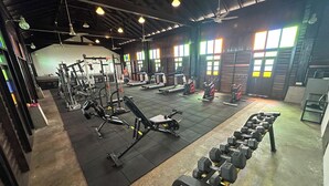 A gym with various exercise equipment, including treadmills, stationary bikes, and weight machines.