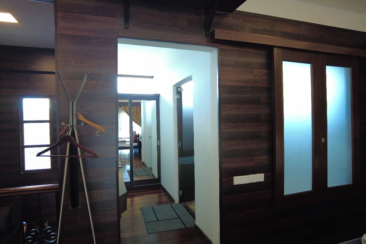 A hallway with wooden paneling, a coat rack, and a mirror.