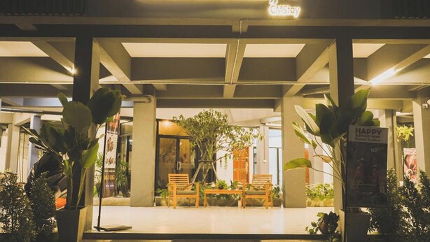 The exterior of Hotel Wualai with a sign indicating it is a CMS hotel. There are potted plants and a seating area with chairs and a table in front. - Hotel Wualai By Cmstay (Chiang Mai)