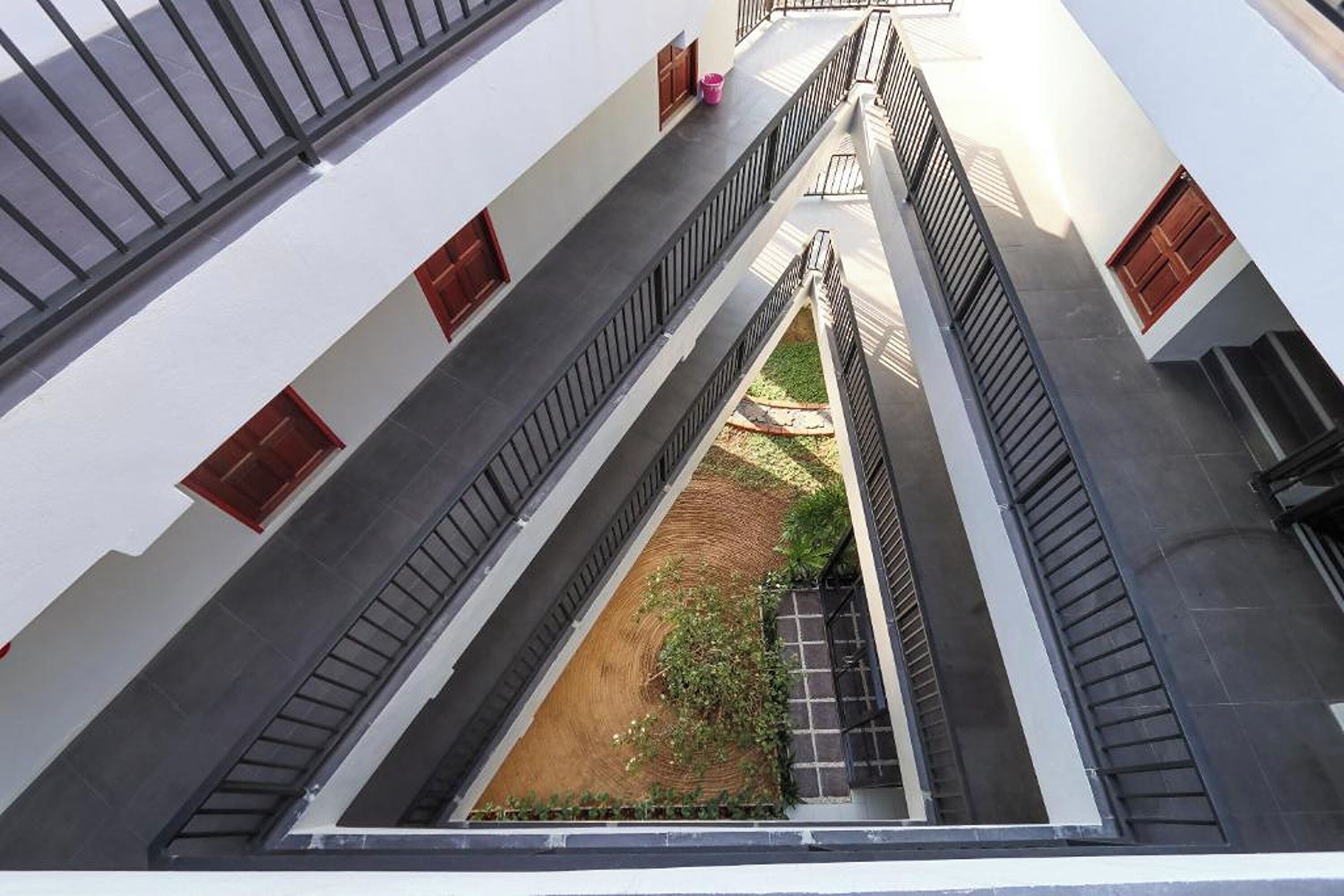Un edificio de varios niveles con un patio central, que cuenta con balcones con barandillas y ventanas.