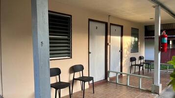 Un espacio al aire libre cubierto con dos puertas, numeradas 1 y 2, y un extintor de incendios fijado a un pilar.