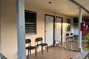 Un espacio al aire libre cubierto con dos puertas, numeradas 1 y 2, y un extintor de incendios fijado a un pilar.