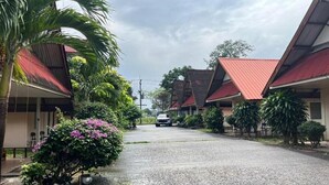 Une rue résidentielle bordée de maisons, avec une route de gravier et une voiture garée.