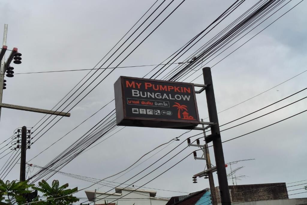 Segnaletica per 'My Pumpkin Bungalow' con simboli che indicano servizi come parcheggio e Wi-Fi.