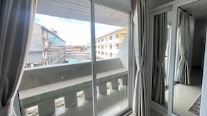 A balcony with a view of buildings and a swimming pool. - W-9 Hotel (Pattaya)