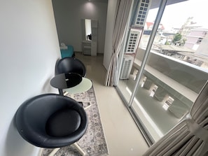 A modern room with a large window, a small table, two chairs, and a mirror. - W-9 Hotel (Pattaya)
