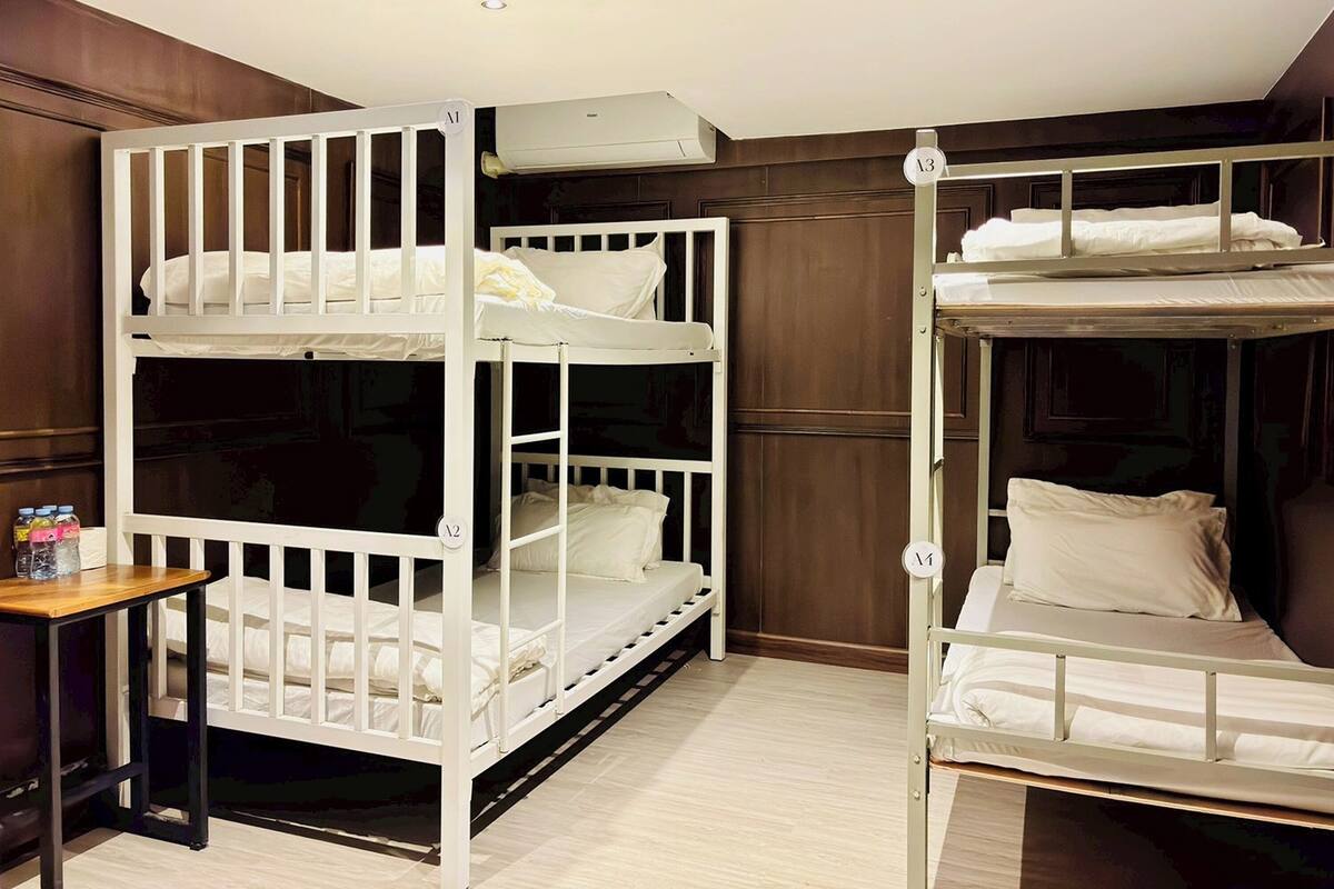 A room with bunk beds, a small table, and a wardrobe.