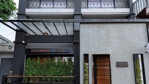 A modern building with a flat roof, large windows, and a metal railing in front. - Sukhum Rajamangala-Phatthanakan Rooms (Bangkok)
