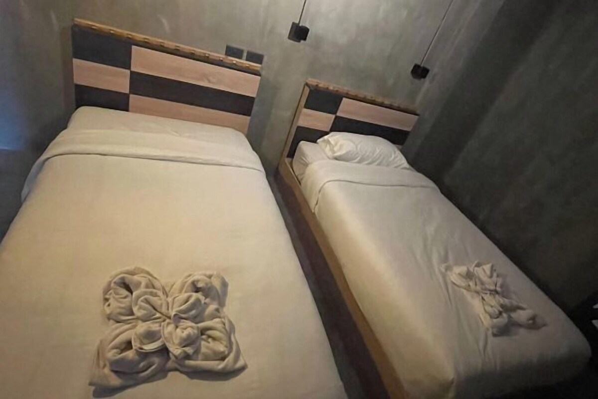 Two single beds with wooden headboards and white linens.
