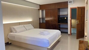 A modern bedroom with a bed, built-in wardrobe, and a television. - Eastan Golf View Chiangmai (Chiang Mai)