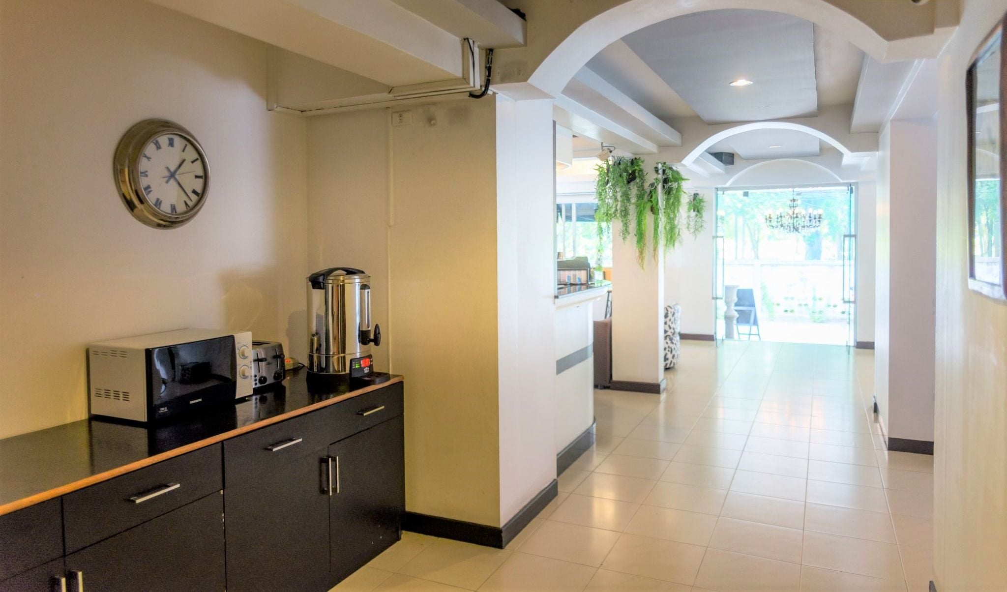 Eine Hotelhalle mit einer Rezeption, einer Uhr und einer Kaffeemaschine.