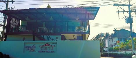 Un edificio con un letrero que dice 'Resort Thai' y un balcón.