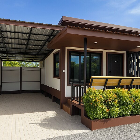 A modern building with a covered patio area, large windows, and a bench. - Resort Thalang (Thep Krasattri)