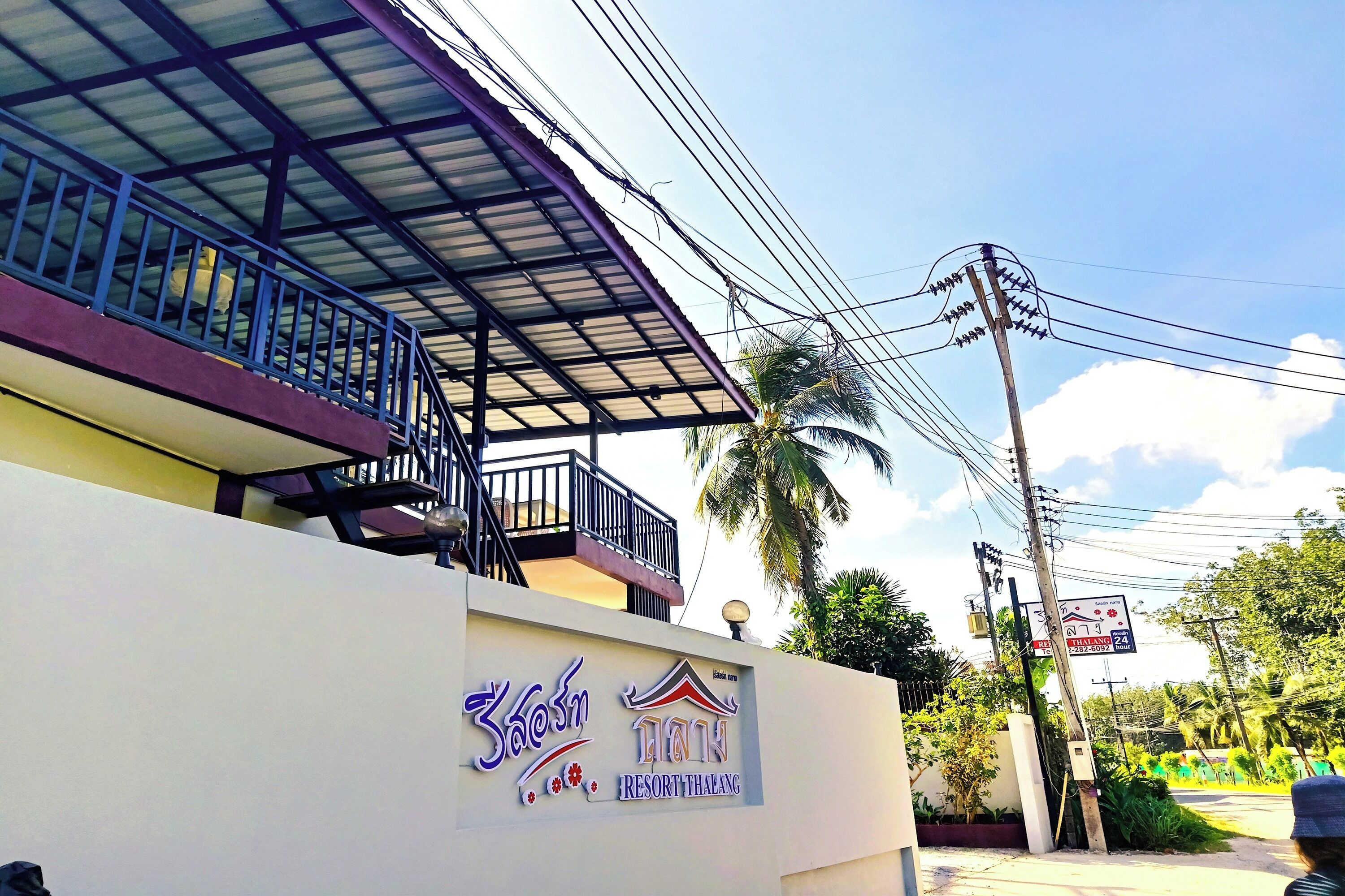 A building with a sign for 'Resort Thalang.'
