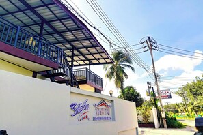 A building with a sign for "360m Resort Thalang" and a balcony with a metal railing. - Resort Thalang (Thep Krasattri)