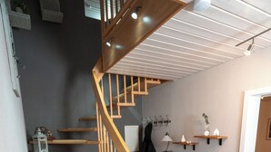 A wooden staircase with rattan steps leading to a landing. - "Glücklich am Harz" dog-friendly vacation home with garden and fireplace (Goslar)