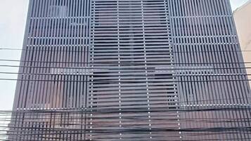 A building with a modern facade featuring vertical slats and a flat roof.