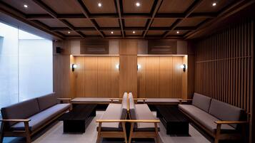 A modern waiting area with wooden paneling, cushioned seating, and built-in lighting.