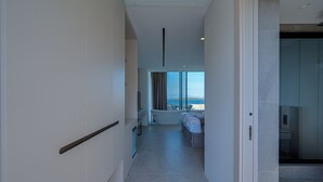 Un pasillo moderno de hotel con vista al mar, un baño y una zona de estar.