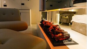Un interior moderno con un sofá, una chimenea y una estantería de pared.