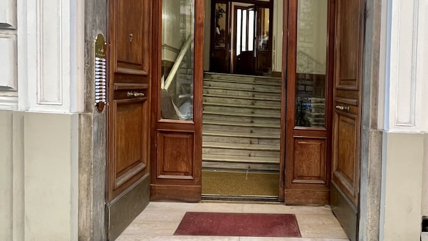 A wooden double door with glass panels leading to a staircase.