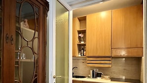A kitchen with wooden cabinets, a built-in oven, and a red rug.