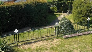 Ein Wohngebiet mit Blick auf einen See, einem Weg und einem eingezäunten Garten.