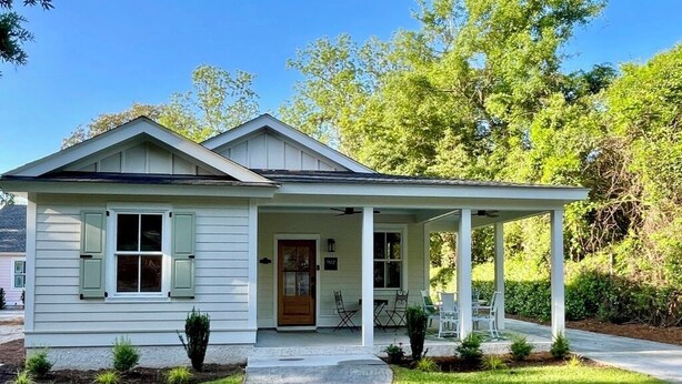 A single-story house with a front porch, a door, and a small garden area. - Oyster Rake Cottage, at Magnolia Court Suites (Beaufort)