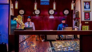 A reception desk with clocks indicating London and Dubai times, a reception sign, and a statue of a horse. - Belvilla Luxury Phoenix East Beach (Dubai)