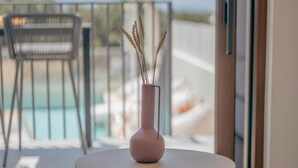A round table with a vase and candles on a balcony overlooking a pool. - Villa Quercus, Aesthete Villas (Rethymno)