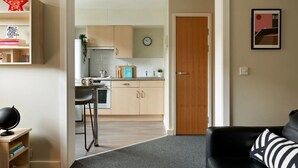 Eine moderne Küche mit Holzschränken, einer Uhr und einer Arbeitsplatte mit einer Pflanze.