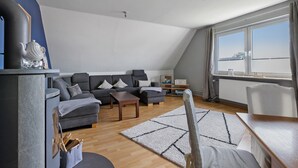 A modern living room with a sofa, coffee table, and a fireplace. - Apartment 'Family Küstenbrise' with Wi-Fi (Heide)