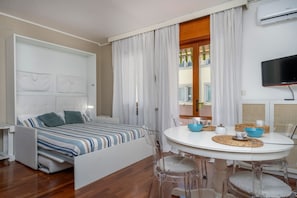 Une chambre moderne équipée d’un lit, d’une table à manger et d’un téléviseur.