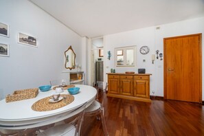 Ein Essbereich mit rundem Tisch, Stühlen und einem Holzschrank.
