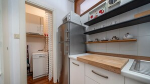 A compact kitchen with a refrigerator, microwave, and wooden countertop. - GuestHost - Cozy 53 sqm apartment, perfect for four people, located on the first floor of a building with an elevator (NOT accessible to disabled guests).The property is located in Grado, known as the Island of the Sun, a beautiful lagoon town famous for (Grago GO)
