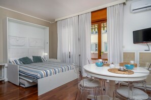 Una habitación moderna con una cama, una mesa de comedor y un televisor.