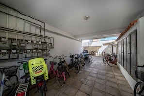 A hallway with bicycles, a water dispenser, and a ceiling light.