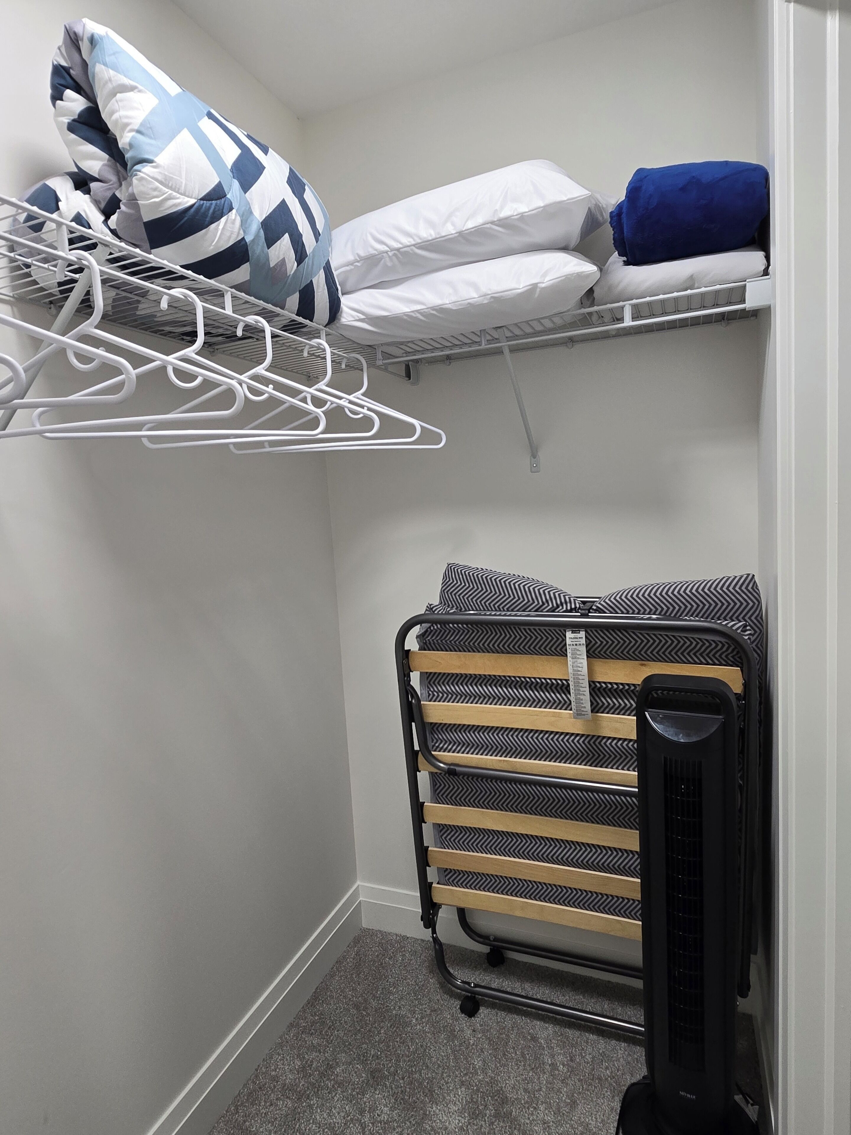 Een kleine, compacte kamer met een stapelbed, een droogrek en een verwarming.