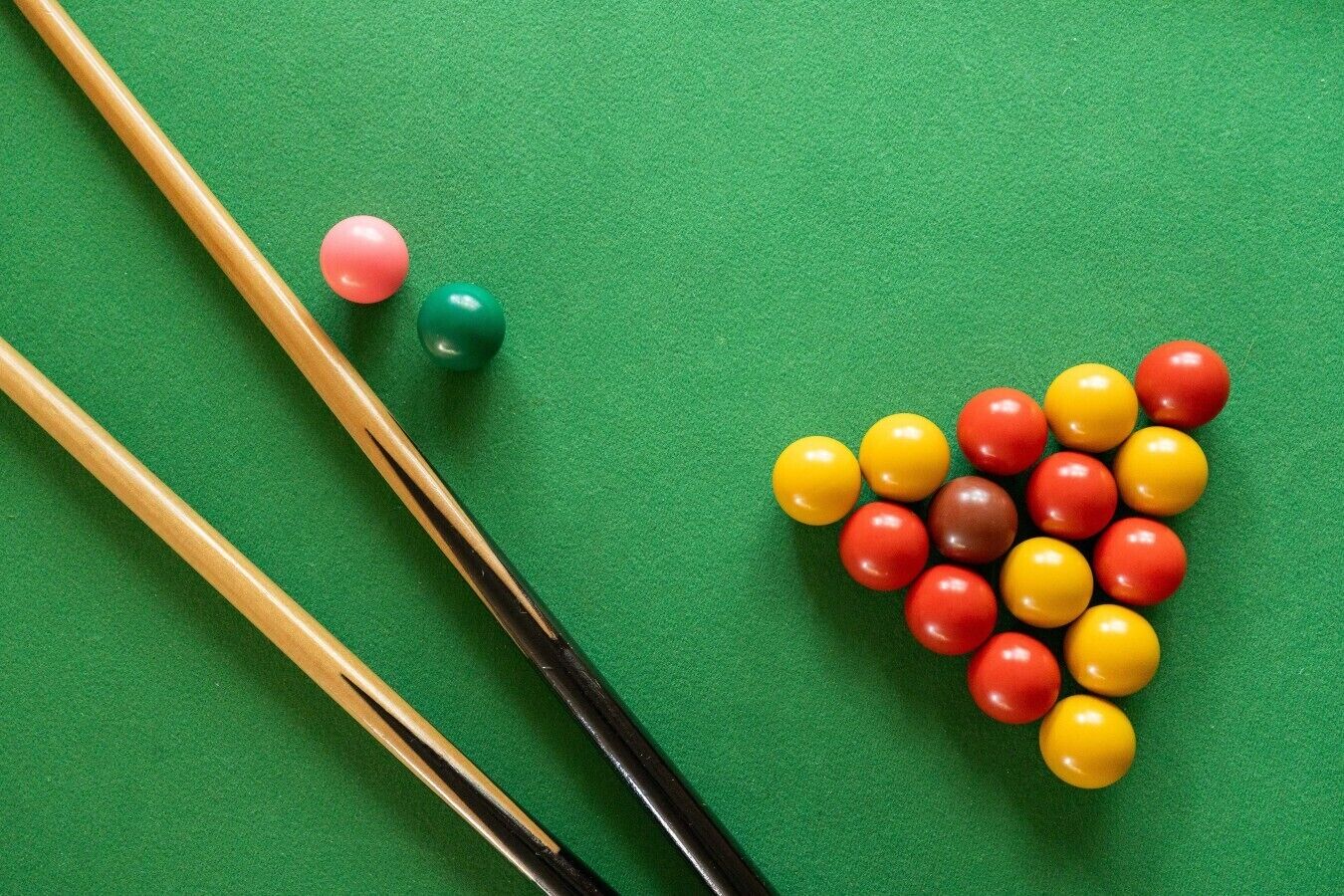 Une table de billard avec des billes et des queues de billard.