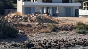 Moderni kaksikerroksinen rakennus, jossa on tasakatto, suuret ikkunat ja parveke.