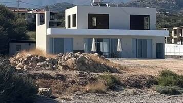 Un bâtiment moderne à deux étages, doté d’un toit plat, de grandes fenêtres et d’un balcon.